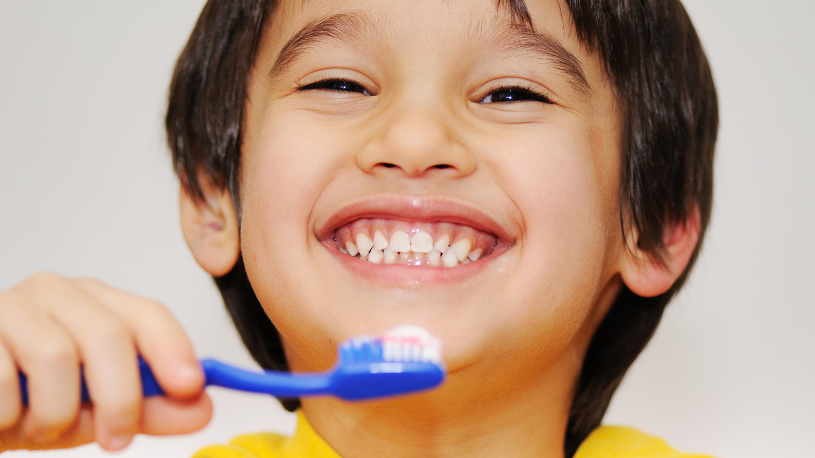 Child holding a tooth brush to brush his teeth